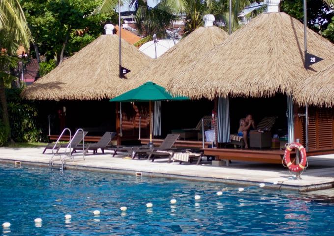 The main pool has several thatched gazebos around it.