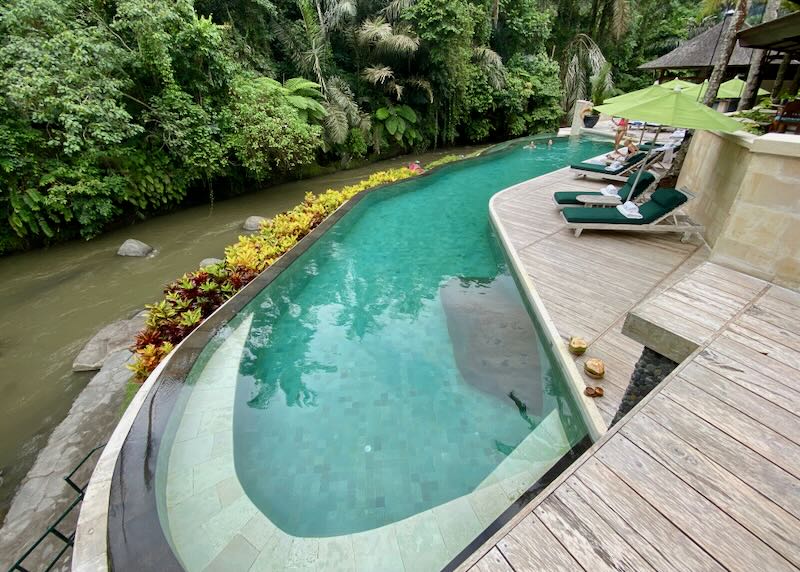 An infinity pool sits next to a river at the Four Seasons Resort Bali at Sayan in Ubud.