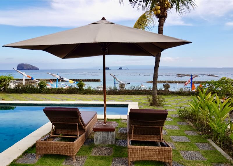 Two lounge chairs sit by the ocean at the Hotel Genggong in Candidasa Bali.
