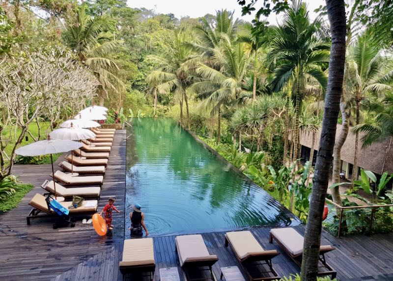 Swimmers enter the infinity pool overlooking the jungle at Komaneka at Bisma Resort in Ubud Bali.