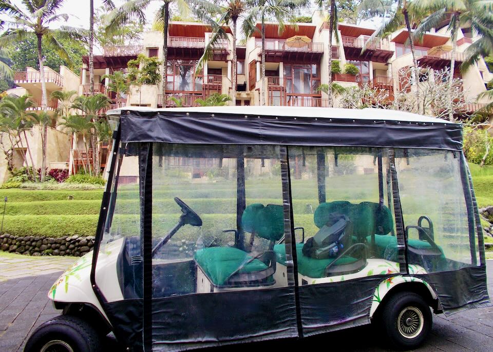 A golf cart sits on the path at the Four Seasons Sayan.