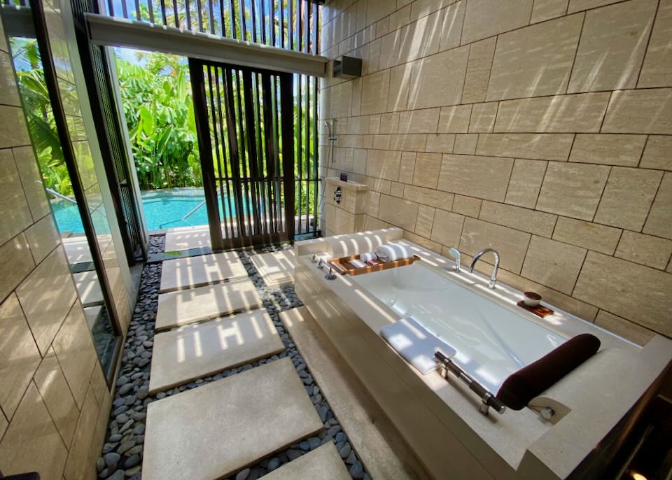 A tub with a view of the outdoor pool.