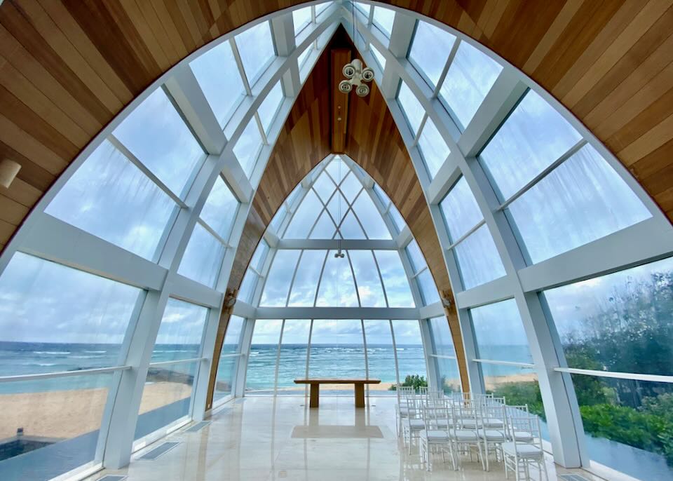 Arched room with floor to ceiling windows with views of the beach.