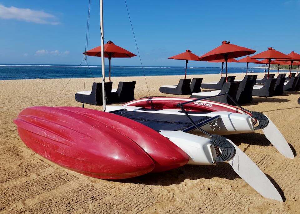 Red kayaks lay on the beach.