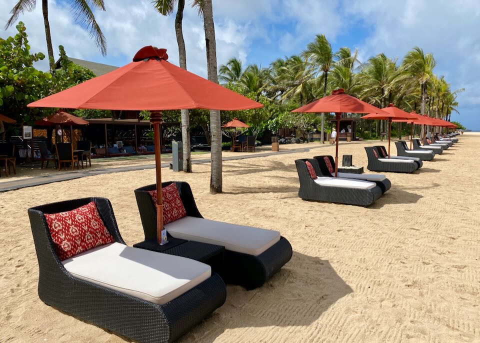 The red umbrella lounge chairs on the beach at the St. Regis resort.