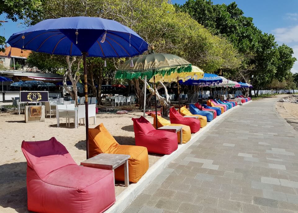 A beach restaurant with colorful chairs.