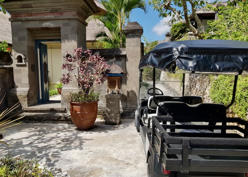 A golf cart parks next to a villa entrance.