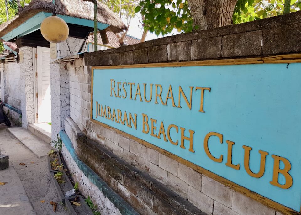 A blue sign that reads Restaurant Jimbaran Beach Club.