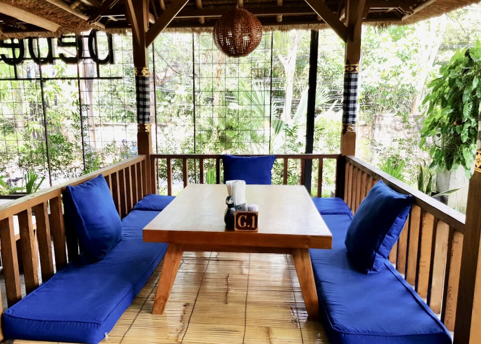 A table at Bebek Bengil with royal blue cushions.