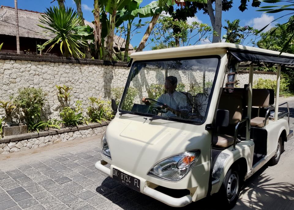 A staff member drives a golf cart.
