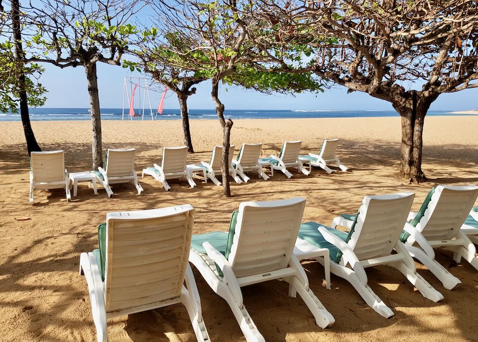 Lounge chairs line the beach.