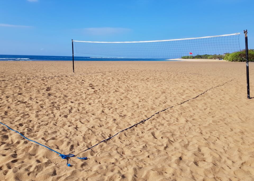 A volleyball net stretches across the beach.