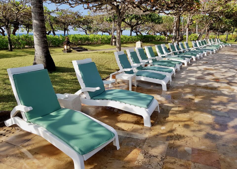 Cushioned lounge chairs sit by the pool.