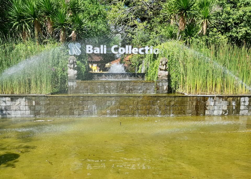 A fountain and pond with a sign that reads, Bali Collection.