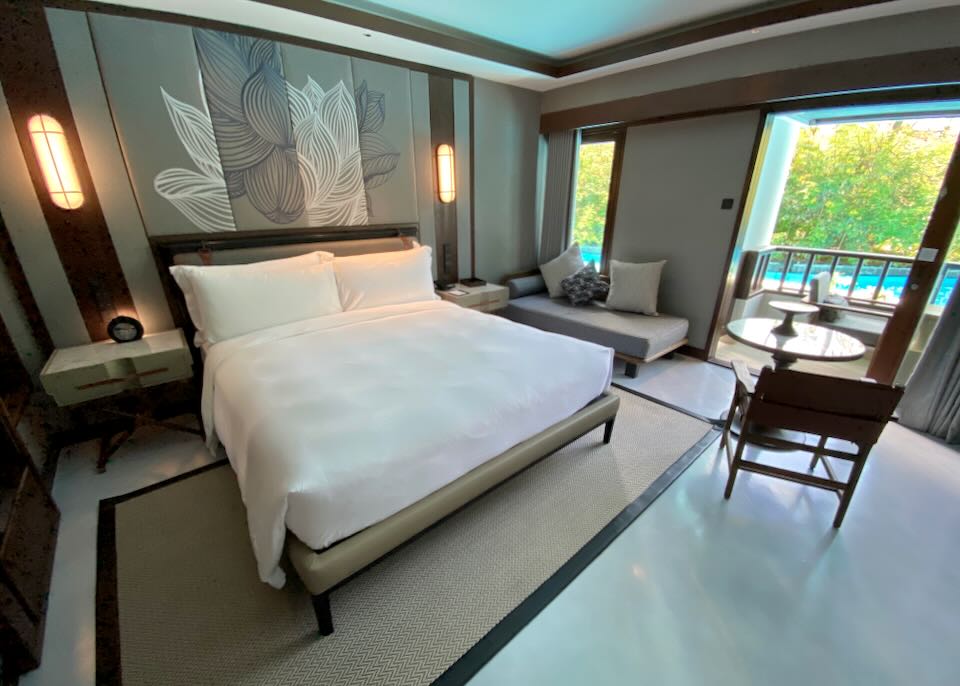 A king bed with a balcony overlooking the lagoon pool.