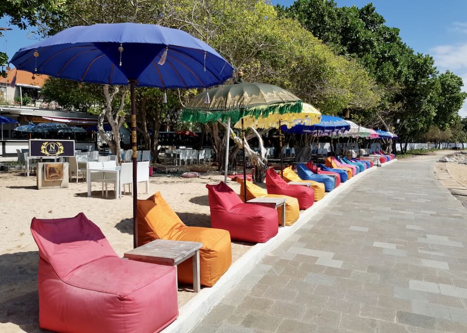 Colorful red beanbags line the beachside path.