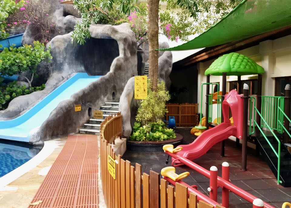 A red slide is next to a water slide.