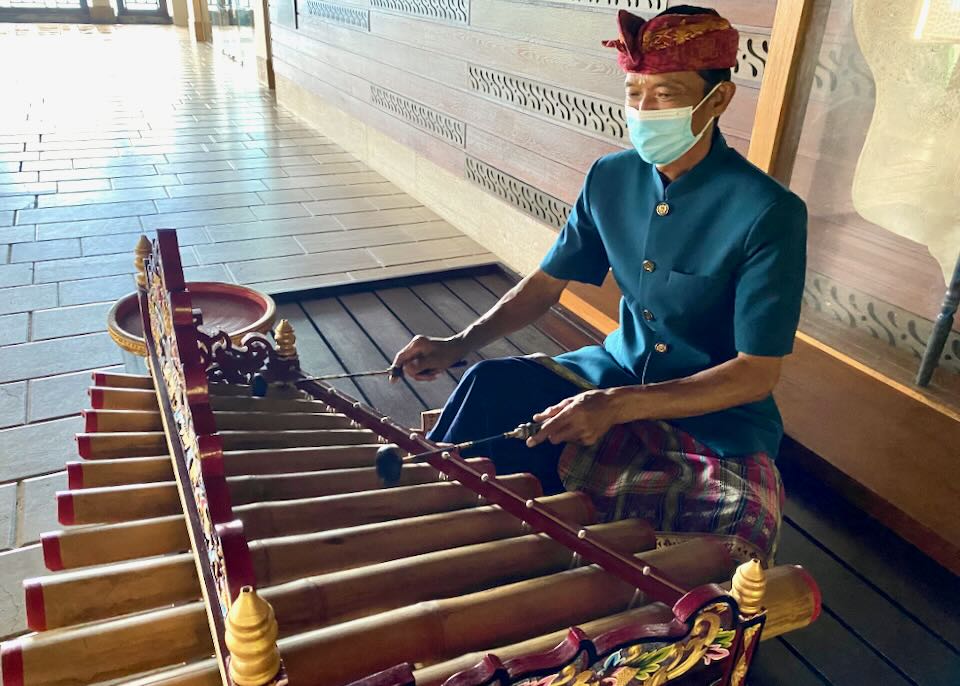 A musician welcomes guests in lobby.