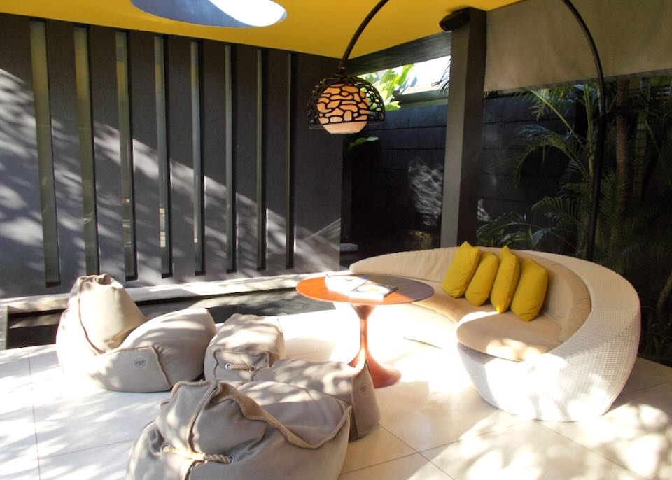 A round couch and bean bag chairs sit on the patio.