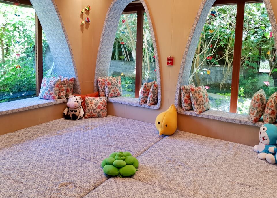 A colorful room with padded floors and window seats.