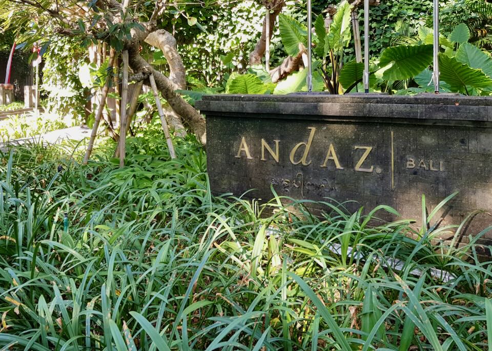 A stone sign with gold letters reads, Andaz, Bali.