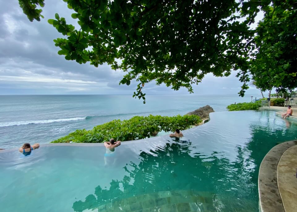 Guests relax by the edge of the infinity pool overlooking the Indian Ocean.