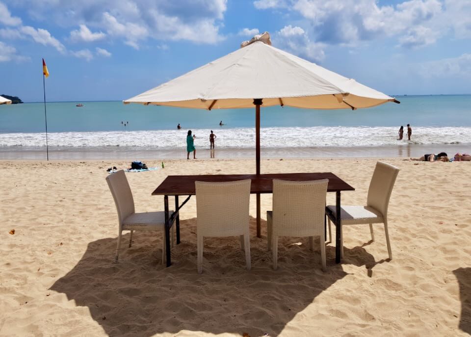 One table with an umbrella sits on the beach.