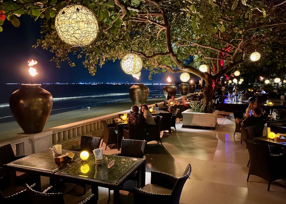 Guest dine at night, outdoors by the beach.