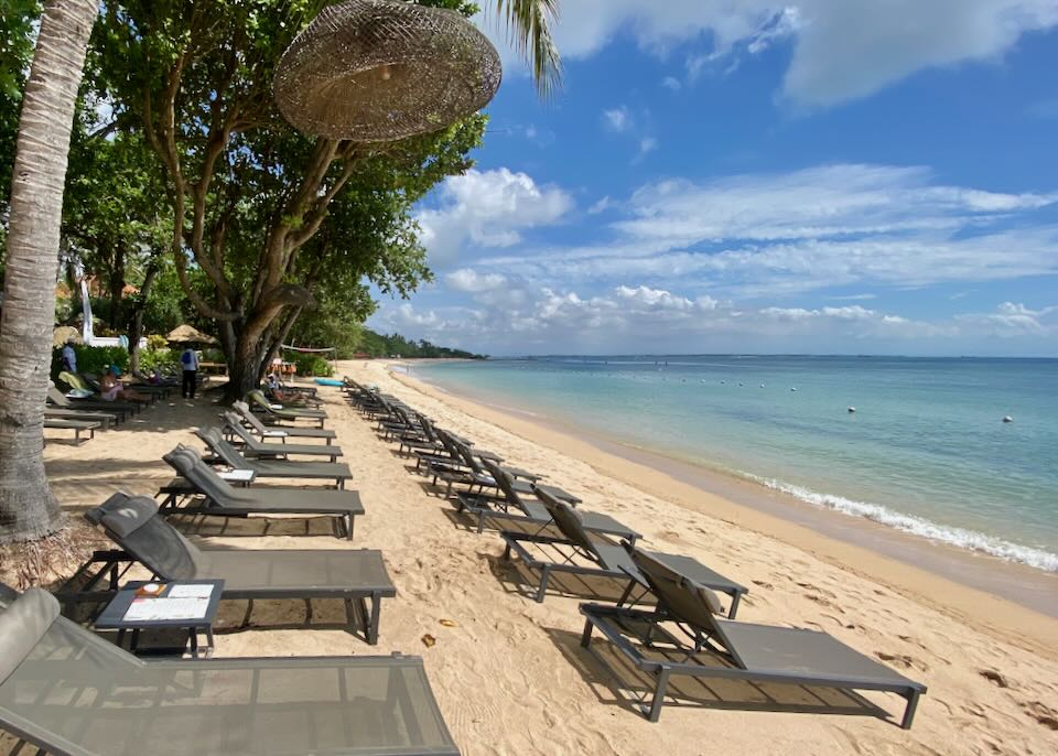 Lounge chairs line the beach.