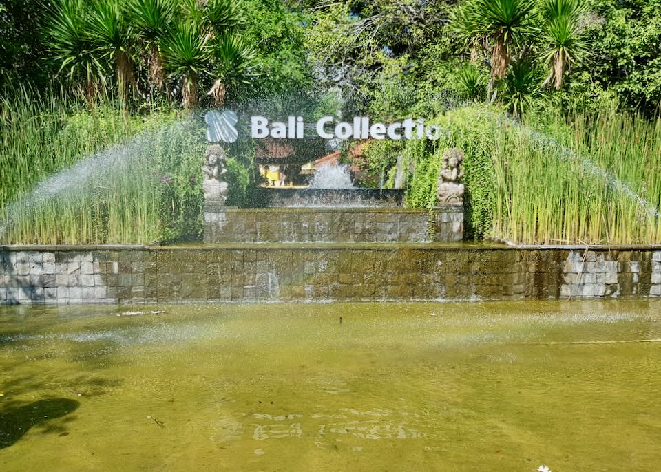 The Bali Collection sign sits in a green pond.