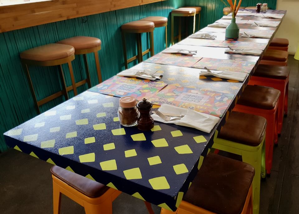 Colorful chairs sit under a bright table.