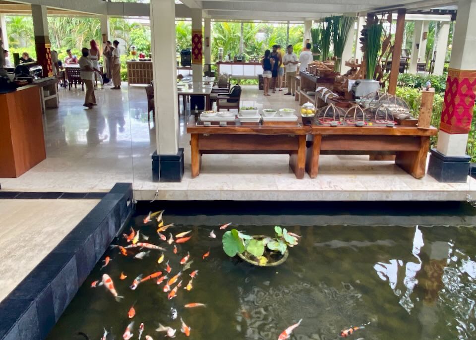 Guests walk through the buffet next to a coy pond.