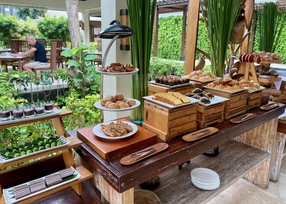 A wood buffet table holds plates of pastries.