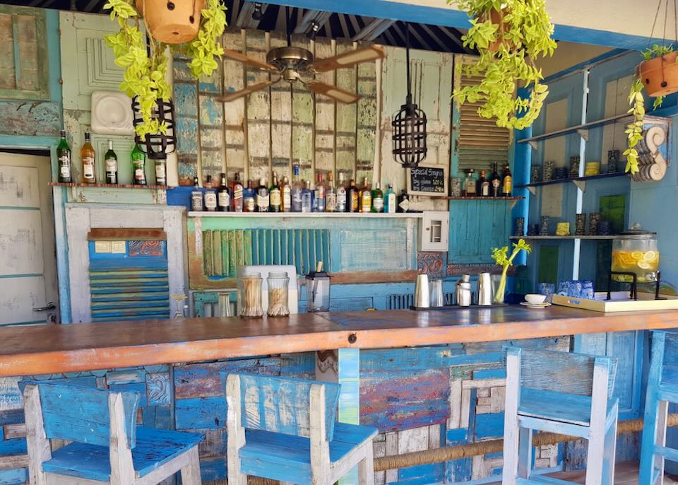 Bright blue wood shutters line a wall behind a bar.
