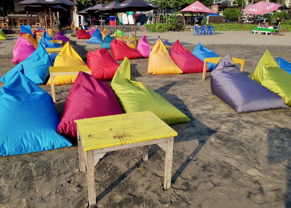 Colorful beanbags lay on the beach.