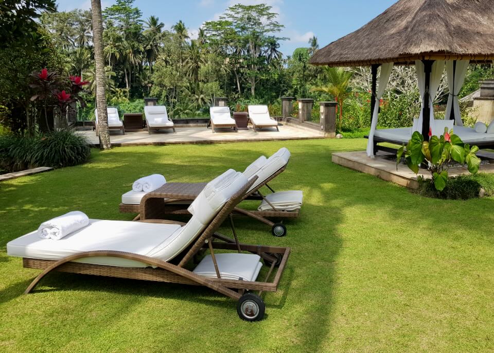 Lounge chairs and a gazebo sits on a green lawn.