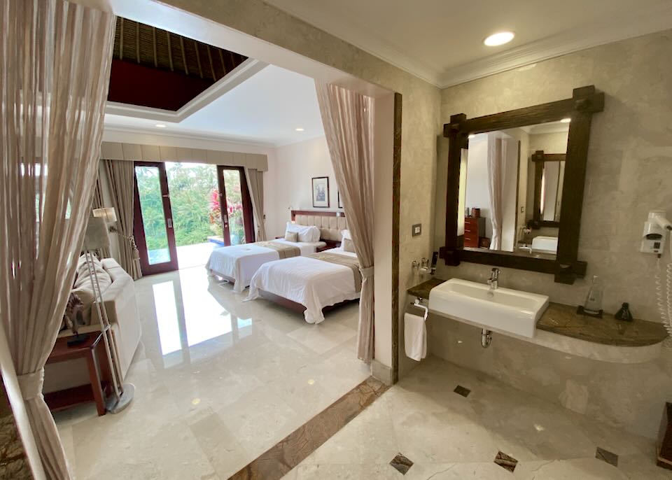 A view of two beds from a bathroom.