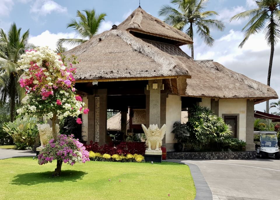 A small white lobby exterior with a thatched roof.