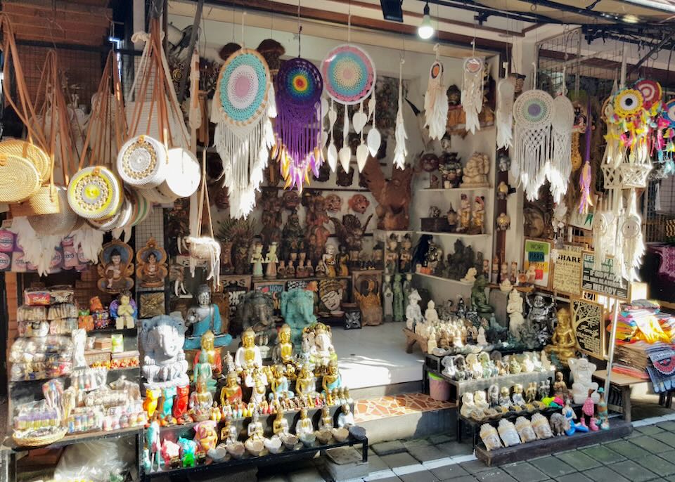 Dream catchers and small statues sit on shelves at a store.
