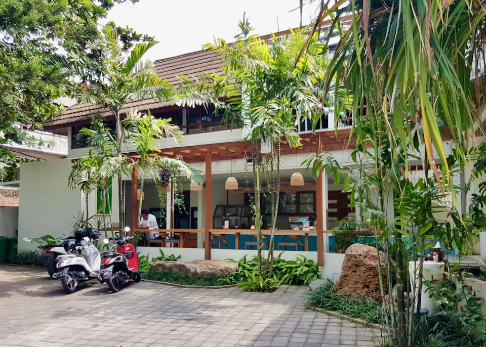 A few motor bikes sit parked in front of the lobby and cafe.