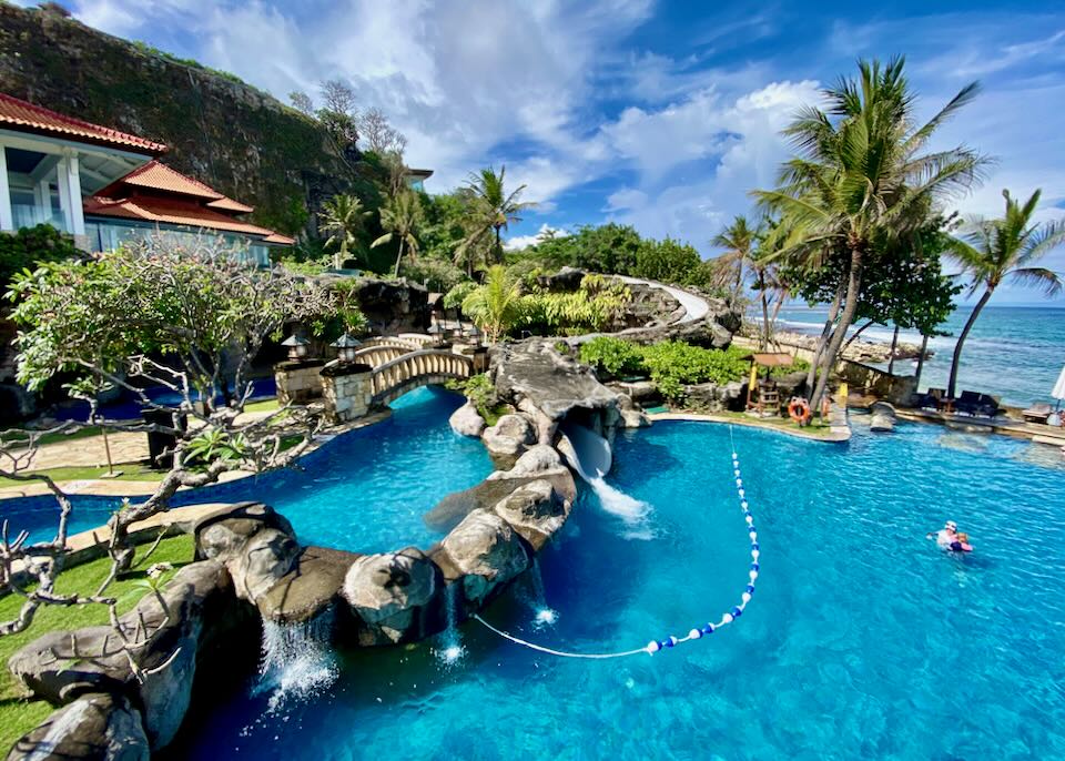 Guests swim in the pool by the ocean.
