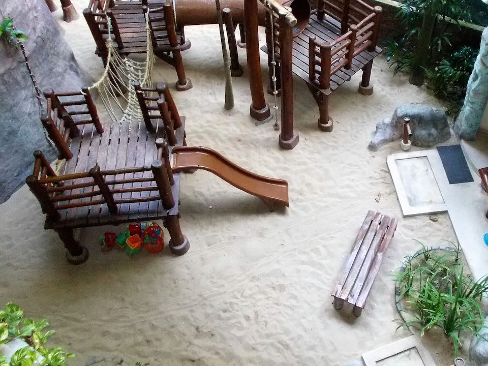 A wooden slide empties onto the sand.