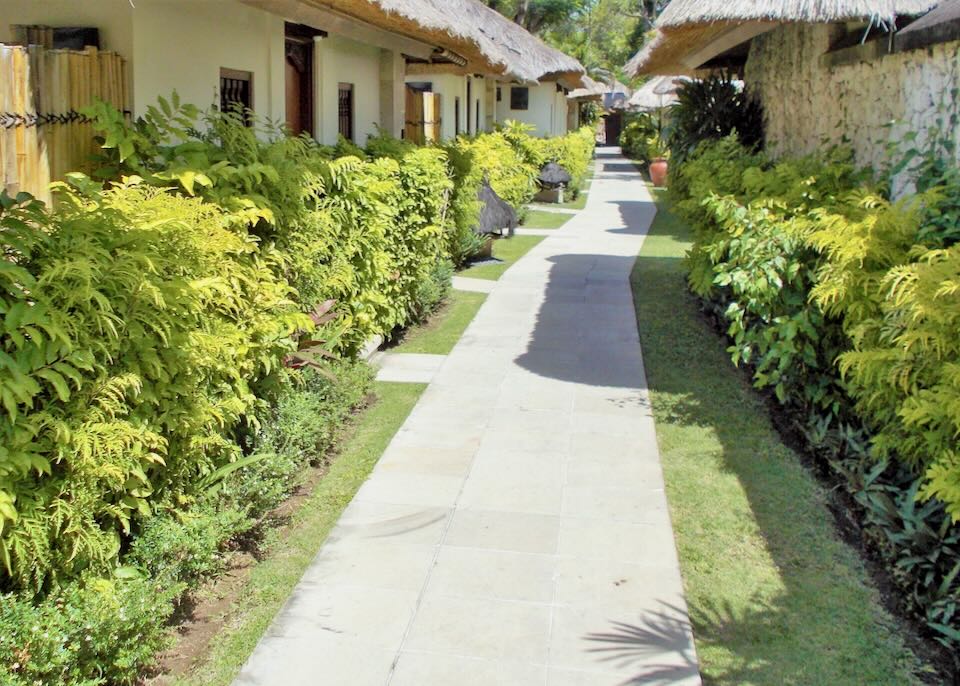 A long sidewalk goes past doors to villas.