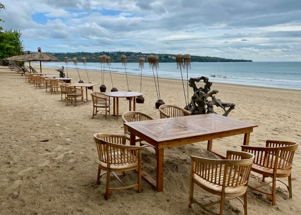 Wood tables sit on the beach.