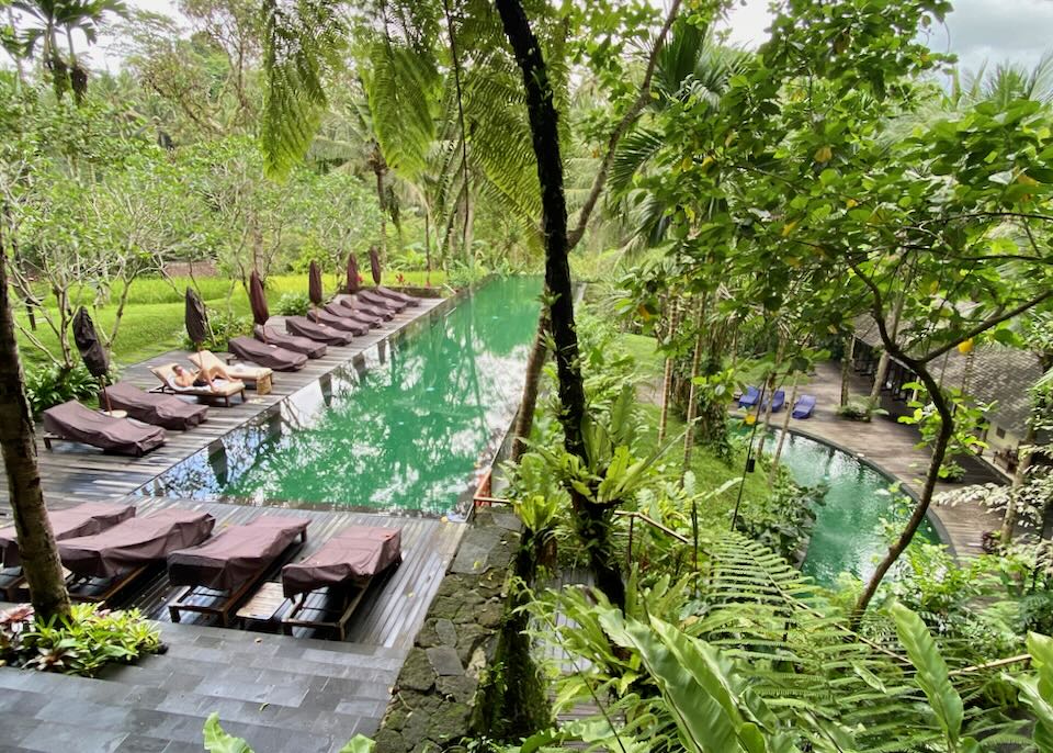 A guest lounges by the pool at Komaneka at Bisma.