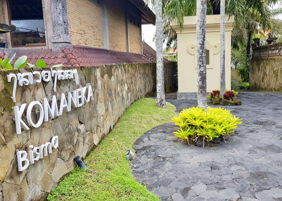 A stone wall with the name Komaneka Bisma in white letters.