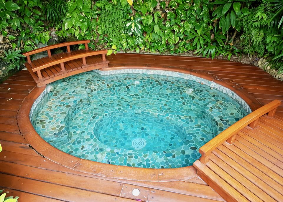 A round hot tub surrounded by a wood deck.