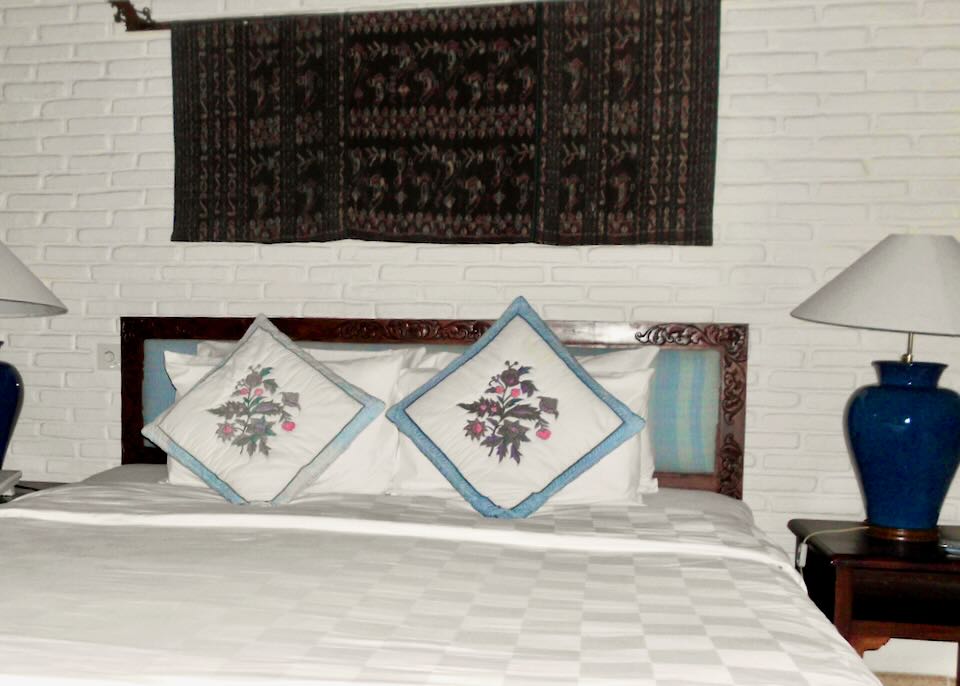 A bed with embroidered pillows .