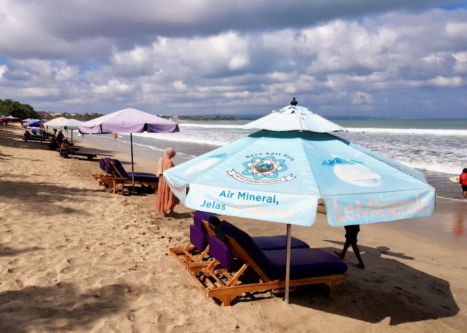 Umbrellas cover lounge chairs on the beach.