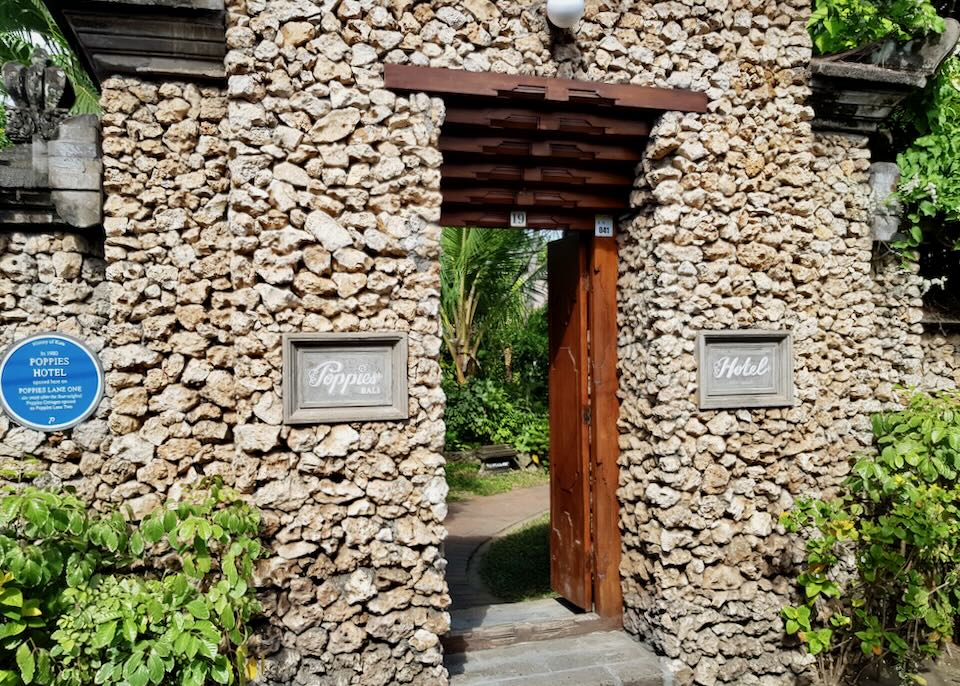 Stone walls and a wood door at the entrance of Poppies Hotel.